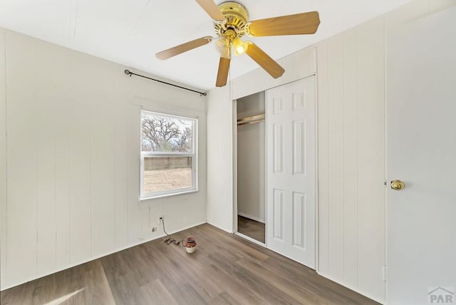 unfurnished bedroom featuring ceiling fan, a closet, and wood finished floors