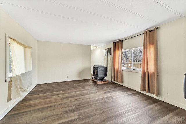 empty room featuring a wood stove and dark wood-type flooring