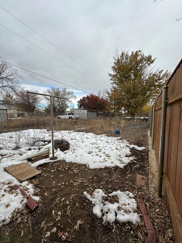 yard covered in snow with fence