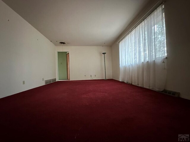 carpeted spare room featuring visible vents