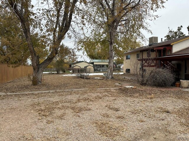 view of yard featuring fence and central air condition unit