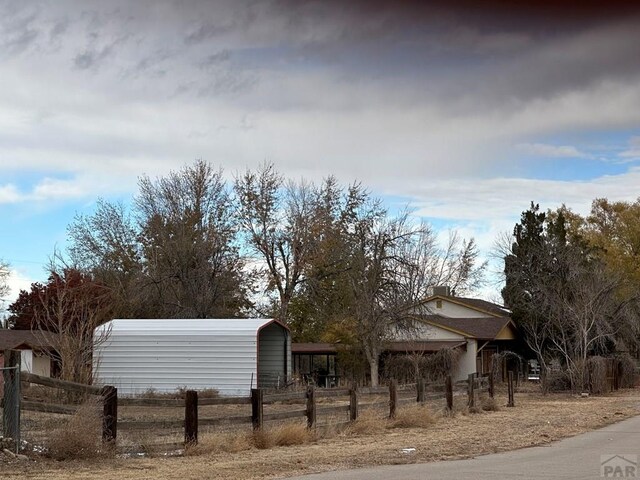 exterior space with fence and a detached carport