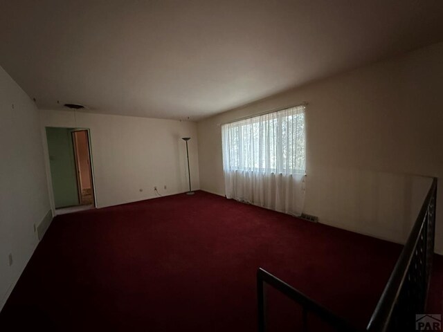 unfurnished room featuring carpet flooring and visible vents