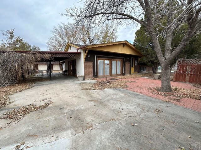 view of front of house with driveway, an attached carport, and brick siding