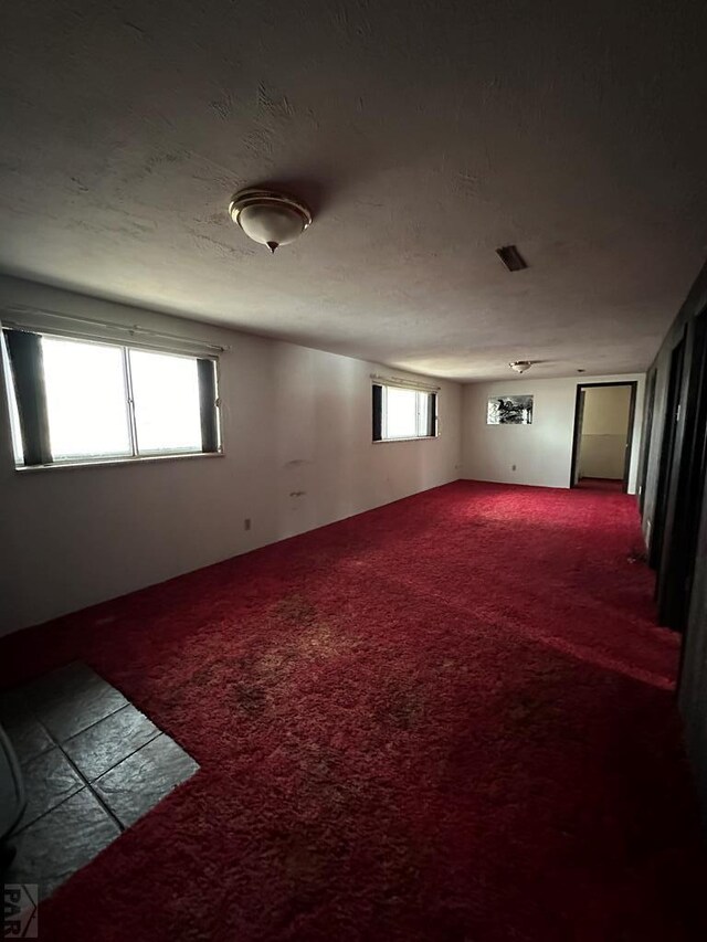 carpeted spare room with a textured ceiling