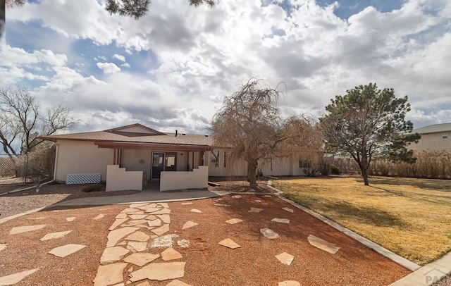 ranch-style house with a patio, a front yard, and stucco siding