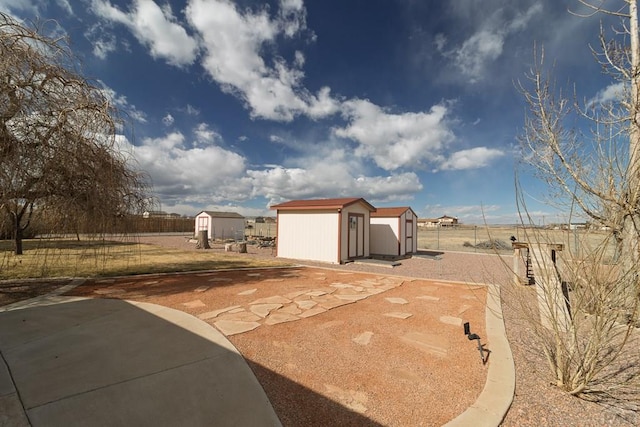 view of yard featuring an outbuilding, a storage shed, and fence