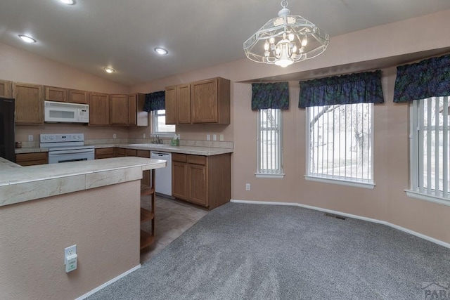 kitchen featuring visible vents, a sink, white appliances, light countertops, and lofted ceiling