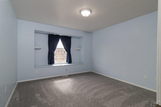 carpeted spare room featuring baseboards