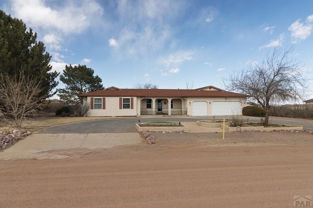 ranch-style home featuring a garage, driveway, and stucco siding