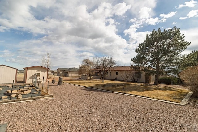 view of yard featuring a garden, a storage shed, and an outdoor structure