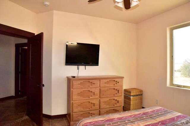 bedroom with ceiling fan, tile patterned flooring, and baseboards