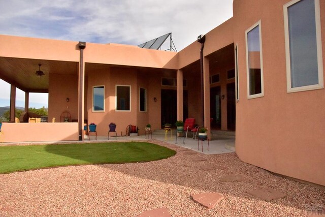 back of property featuring a patio and stucco siding