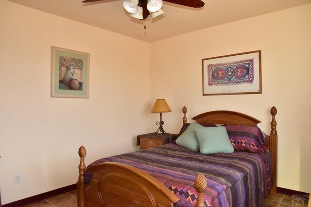 tiled bedroom featuring ceiling fan and baseboards