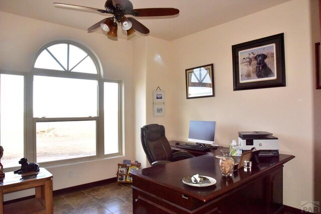 home office with a ceiling fan and baseboards