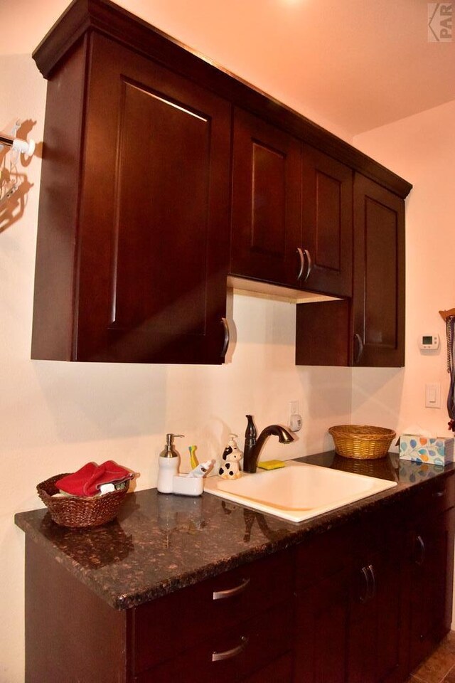 kitchen with dark stone countertops and a sink