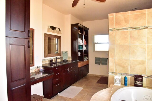 full bath featuring a whirlpool tub, ceiling fan, vanity, and tile patterned floors