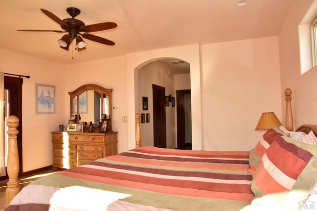 bedroom with a ceiling fan and arched walkways