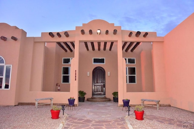 doorway to property with a patio and stucco siding