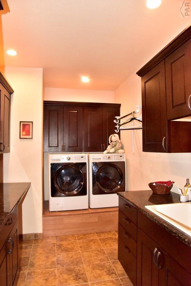 laundry area featuring cabinet space, washer and clothes dryer, a sink, and recessed lighting