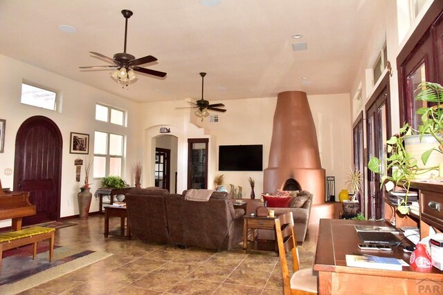 living room featuring arched walkways, visible vents, and ceiling fan