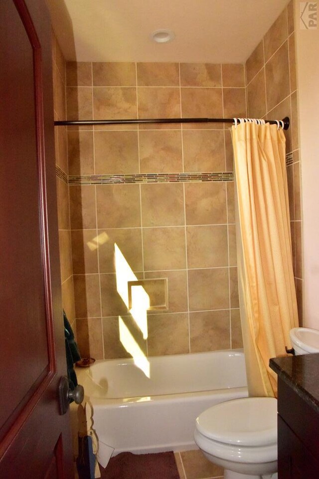 bathroom with vanity, toilet, and shower / bathtub combination with curtain