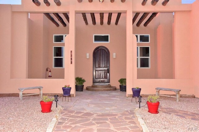 property entrance featuring a patio and stucco siding