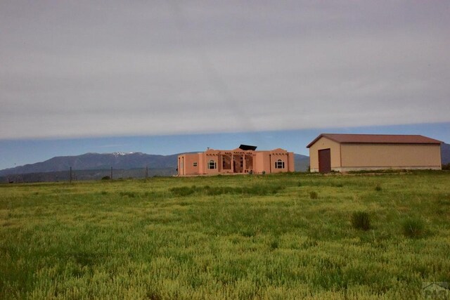 view of yard with a mountain view, an outdoor structure, and an outbuilding