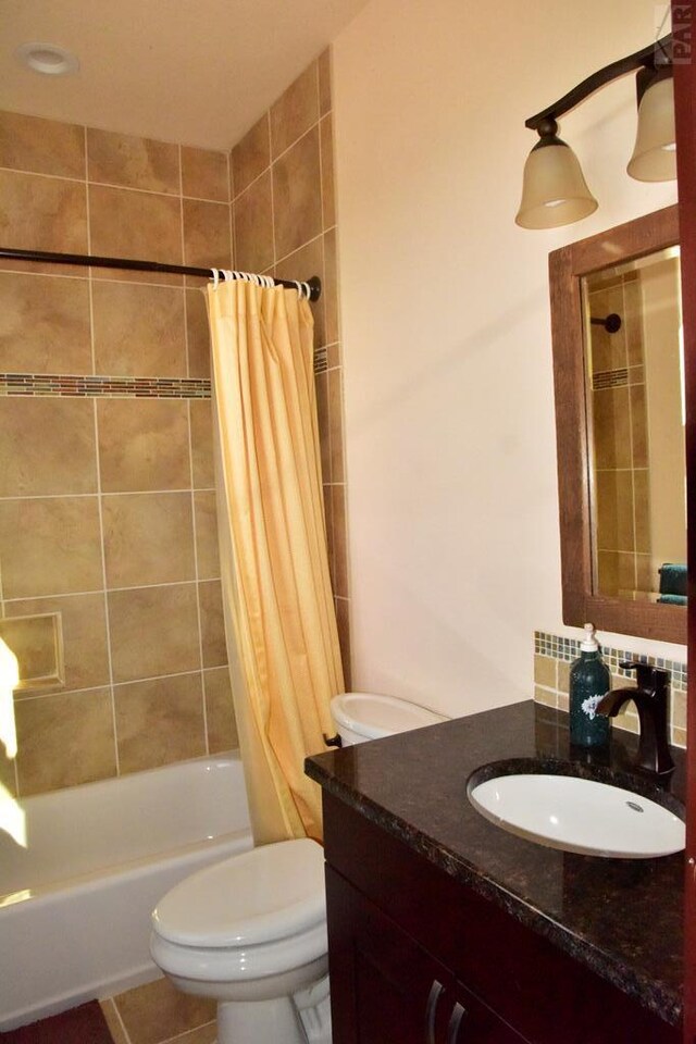 bathroom with shower / bath combination with curtain, vanity, and toilet