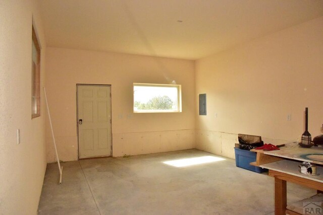 interior space with concrete floors and electric panel