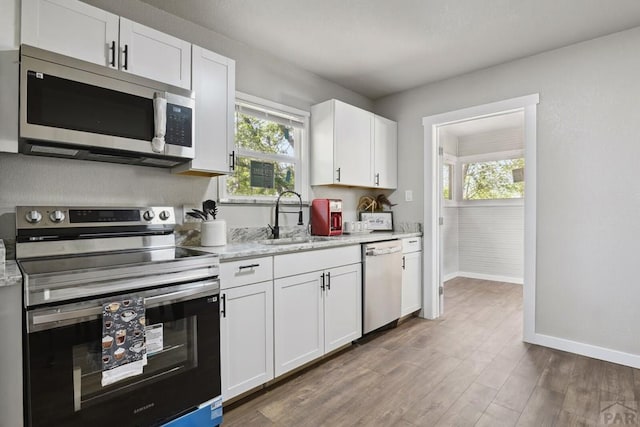 1934 E 11th St, Pueblo, CO 81001 - kitchen featuring appliances with stainless steel finishes, a sink, baseboards, and plenty of natural light