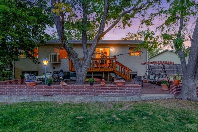 back of house with stucco siding, fence, a patio, a wooden deck, and stairs