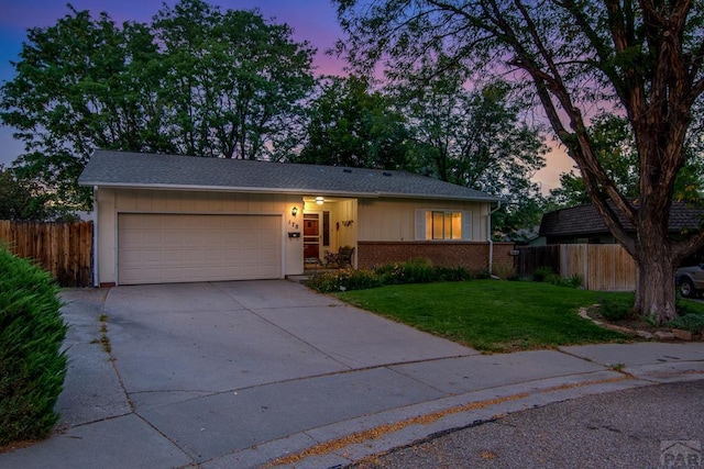 ranch-style home with a garage, fence, a front lawn, and concrete driveway