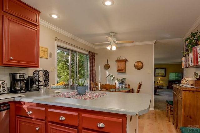 kitchen featuring ornamental molding, light wood-style floors, a peninsula, and light countertops