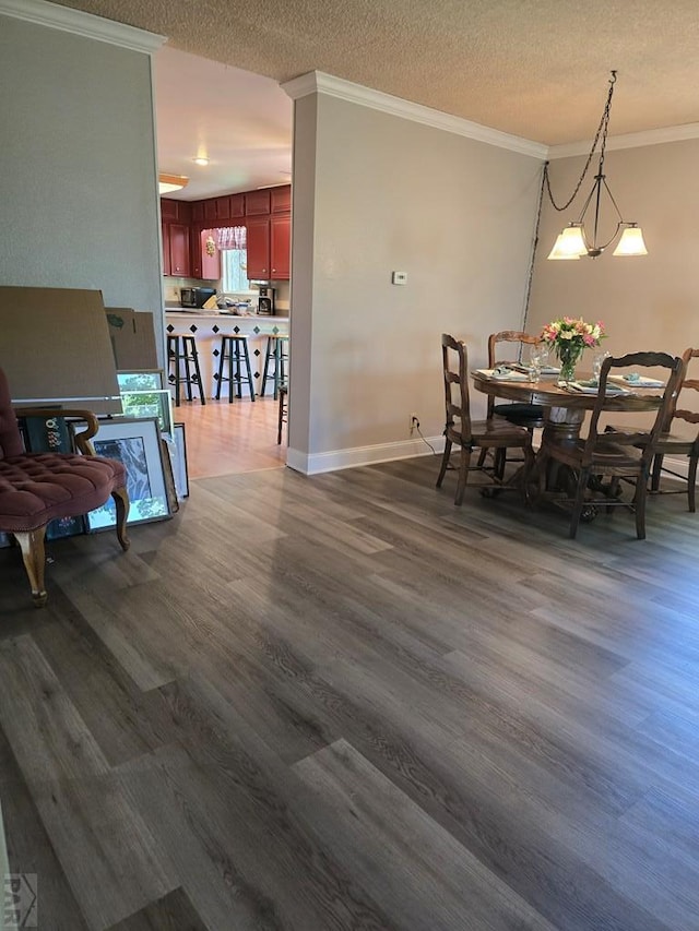 178 Macneil Pl, Pueblo, CO 81001 - dining room featuring ornamental molding, a textured ceiling, baseboards, and dark wood-style floors