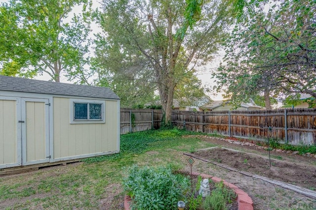 view of yard with an outdoor structure, a shed, and a fenced backyard