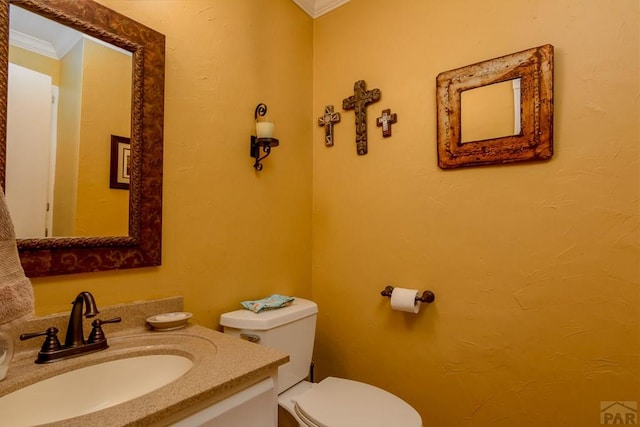 bathroom with vanity, toilet, and crown molding