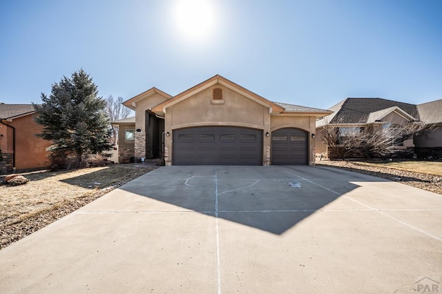 view of front of property with driveway, an attached garage, and stucco siding