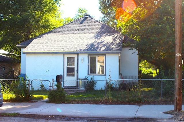 view of front of house featuring roof with shingles and a fenced front yard