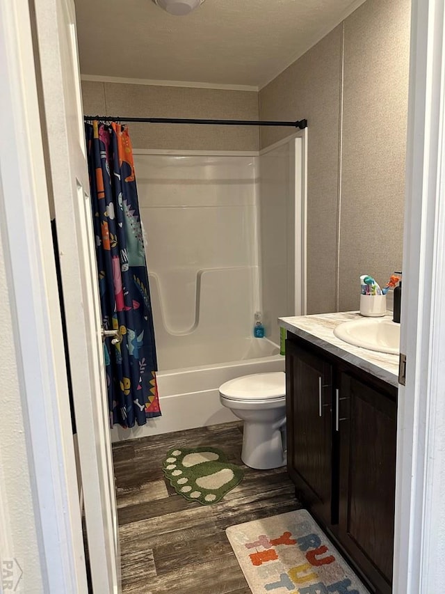 full bathroom featuring toilet, shower / bath combination with curtain, wood finished floors, and vanity