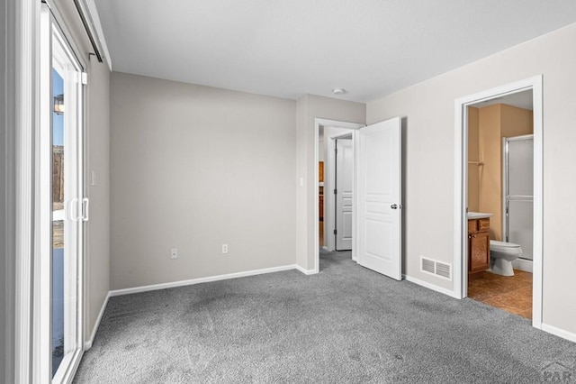 unfurnished bedroom featuring carpet floors, ensuite bath, baseboards, and visible vents