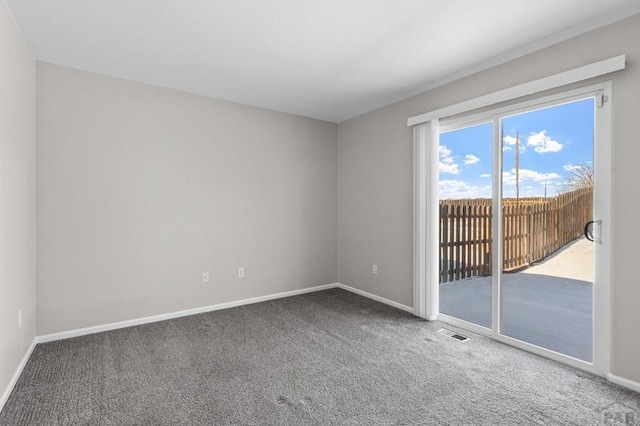 spare room with carpet, visible vents, and baseboards