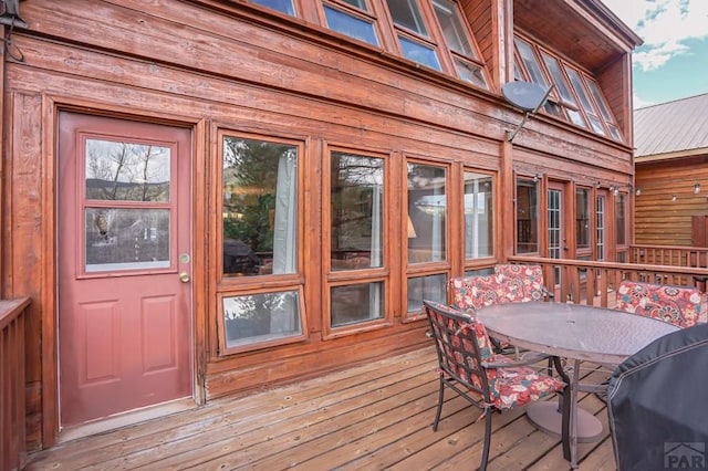 wooden terrace with outdoor dining area and area for grilling