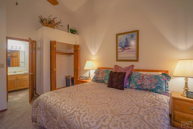 bedroom with a closet, a towering ceiling, ensuite bathroom, light carpet, and a sink