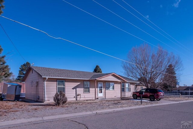 single story home with roof with shingles and fence