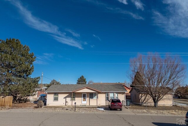 ranch-style house featuring fence