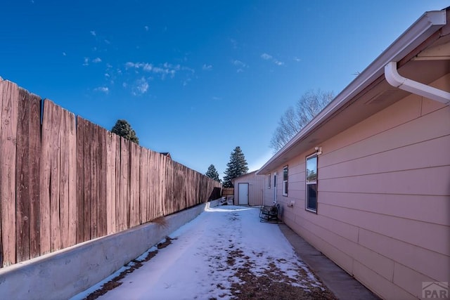 view of snow covered exterior with fence