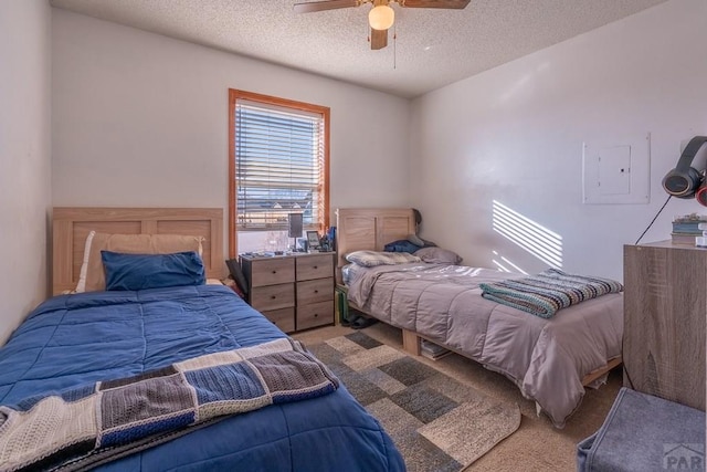 carpeted bedroom featuring a ceiling fan, electric panel, and a textured ceiling