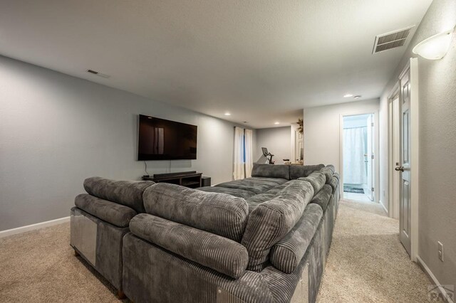 living room with light colored carpet, visible vents, and baseboards