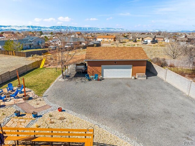 view of front of house featuring a residential view, gravel driveway, a mountain view, and fence